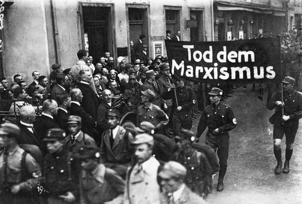 Der erste Parteitag der neugegründeten NSDAP im Juni 1926 fand in Weimar statt, da Adolf Hitler in Bayern noch Redeverbot hatte. Vorbeimarsch der SA-Verbände vor Adolf Hitler (im Auto stehend), die ein Transparent mit der Aufschrift »Tod dem Marxismus« tragen, vor Hitler der »Frankenführer« Julius Streicher.