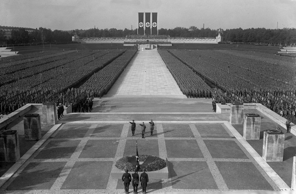 Reichsparteitag der NSDAP vom 5. bis 10. September 1934 in Nürnberg, Appell von SA und SS in der Luitpolt-Arena vor Adolf Hitler, Viktor Lutze (Chef des Stabs der SA) und Heinrich Himmler (Reichführer der SS), ganz im Vordergrund die »Blutfahne« vom 9. November